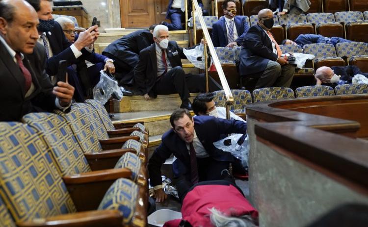 People shelter in the House gallery as protesters try to break into the House Chamber at the U.S. Capitol on Wednesday in Washington. (ANDREW HARNIK/Associated Press)