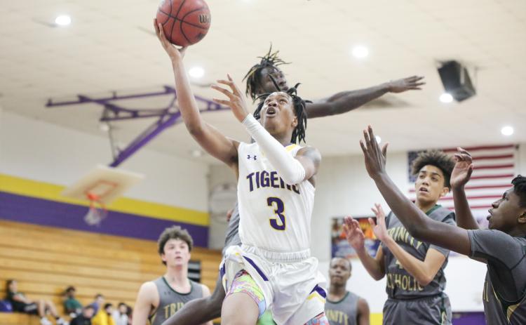 Columbia guard Charleston Ponds rises for a layup against Trinity Catholic on Tuesday night. (BRENT KUYKENDALL/Lake City Reporter)