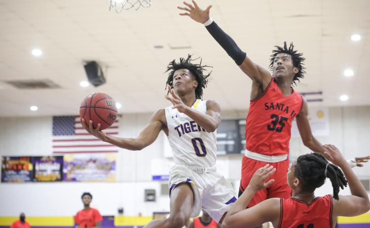 Columbia guard Dante Brown soars past Santa Fe center Jonathan Lee to score a layup on Thursday night. (BRENT KUYKENDALL/Lake City Reporter)