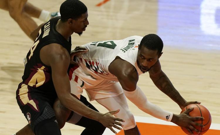Miami guard Elijah Olaniyi (4) looks to pass the ball as Florida State guard Sardaar Calhoun (24) defends on Wednesday in Coral Gables. (MARTA LAVANDIER/Associated Press)
