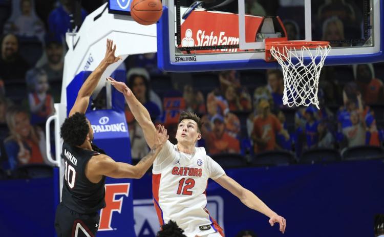 South Carolina forward Justin Minaya (10) makes a shot over Florida forward Colin Castleton (12) during the first half Wednesday in Gainesville. (MATT STAMEY/Associated Press)