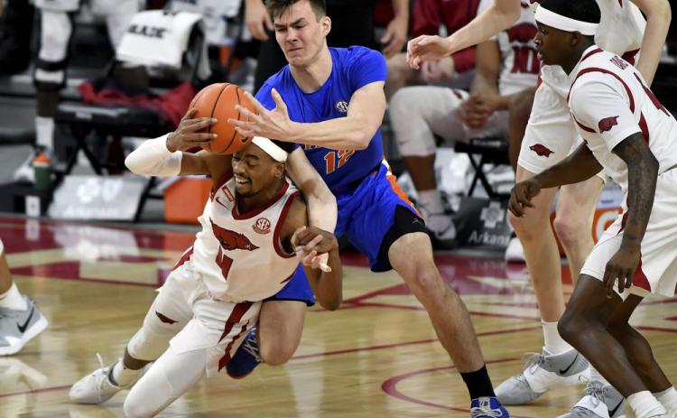 Arkansas guard Jalen Tate (11) and Florida forward Colin Castleton (12) fight for a rebound during Tuesday's game in Fayetteville, Ark.. (MICHAEL WOODS/Associated Press)