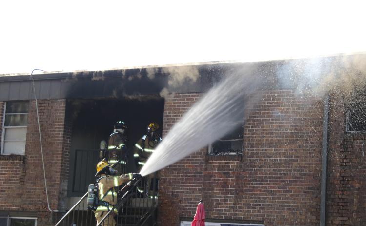 Firefighters battle a structure fire that destroyed four apartments in the Columbia Arms Apartment Complex Saturday. The cause of the fire remains under investigation. (TONY BRITT/Lake City Reporter)