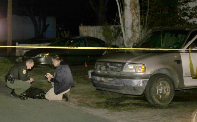 Columbia County Sheriff’s Office investigators search the ground for evidence after deputies found two juveniles shot near the intersection of Southeast Lochlynn and Southeast Putnam Street Tuesday afternoon. No arrests have been made in the case. (TONY BRITT/Lake City Reporter)