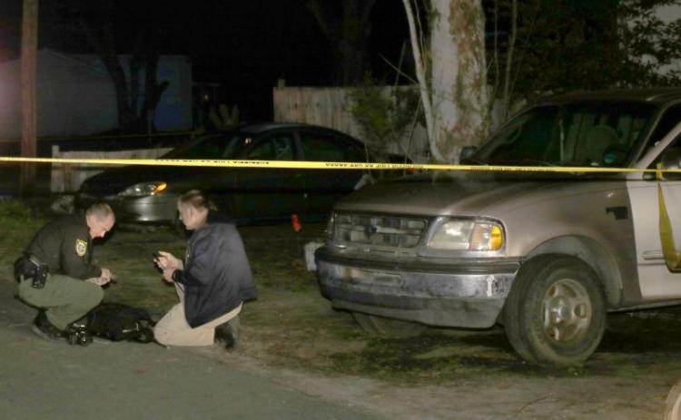 Columbia County Sheriff’s Office investigators search the ground for evidence after deputies found two juveniles shot near the intersection of Southeast Lochlynn and Southeast Putnam Street Tuesday afternoon. No arrests have been made in the case. (TONY BRITT/Lake City Reporter)