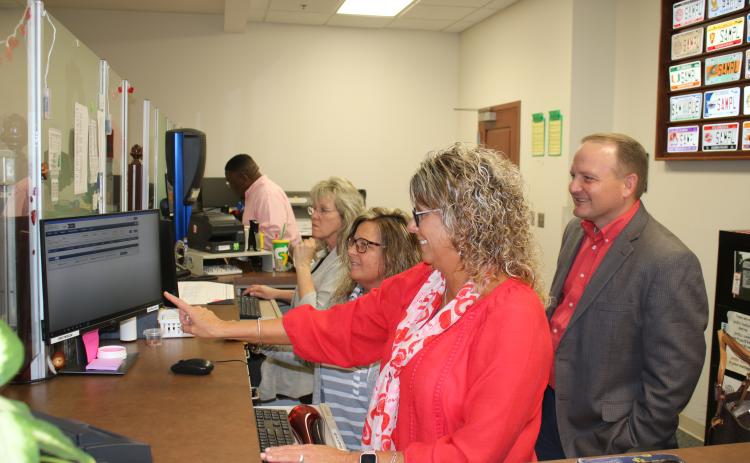 Sherrie Thomas (clockwise from left), Tracy Duckett, and Tammy Hartley, Columbia County Tax Collectors Office employees, show Kyle Keen, Columbia County tax collector, information on the new ORION software Tuesday afternoon. The tax collectors office will be closed Monday while employees take a day of in-service training to learn the new system. (TONY BRITT/Lake City Reporter)