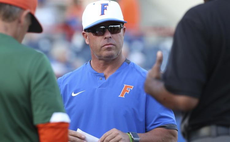 Florida coach Kevin O'Sullivan meets with umpires before his team’s game against Florida A&M on March 4, 2020, in Gainesville. (AP FILE PHOTO)