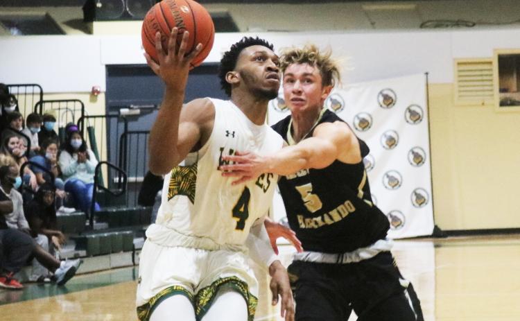 FGC guard Antonio Card rises on the fast break to score as PHSC guard Hayden Greene gives chase on Thursday night at the Howard Center. (JORDAN KROEGER/Lake City Reporter)