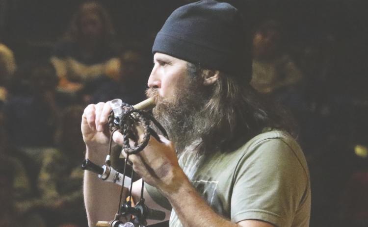 Jason Silas “Jase” Robertson, one of the stars on the show ‘Duck Dynasty,’ demonstrates one of his duck calls Thursday night at the Christ Central church. (MORGAN MCMULLEN/Lake City Reporter)