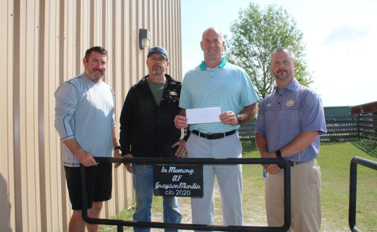 Andy Bennett (from left), Westside Elementary School physical education teacher; stands with Darryl Thomas, Columbia High School welding teacher; Dennis Dotson, Westside Elementary School principal; and Trey Hosford, Columbia High School principal; during a brief presentation Wednesday morning where the Grayson Martin Memorial Welding Scholarship was established at the Columbia High School welding lab. Martin was killed in a wreck weeks earlier. (TONY BRITT/Lake City Reporter)