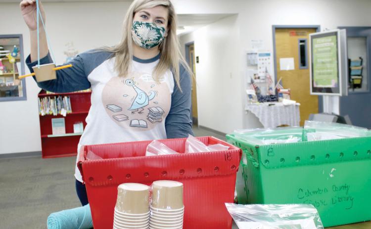 Kate Duong, the youth services librarian for the Columbia County Public Library, shows off the bird feeder students can make in the Backyard Birds kit. (TONY BRITT/Lake City Reporter)