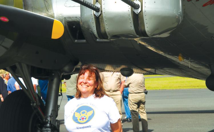 Catherine Feyerabend of Clearwater stands underneath the ‘Aluminum Overcast’ on Sunday. She said flying in a B-17 like her father had been on her bucket list. (JAMIE WACHTER/Lake City Reporter)