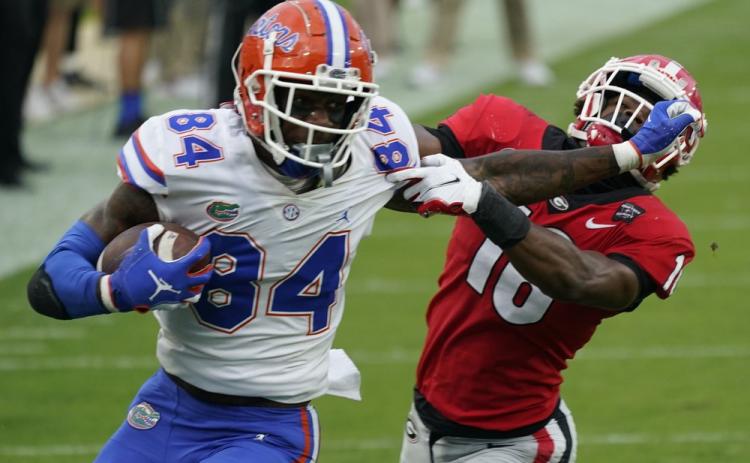 Florida tight end Kyle Pitts (84) tires to get past Georgia defensive back Lewis Cine (16) after a reception on Nov. 7, 2020, in Jacksonville. (AP PFILE PHOTO)