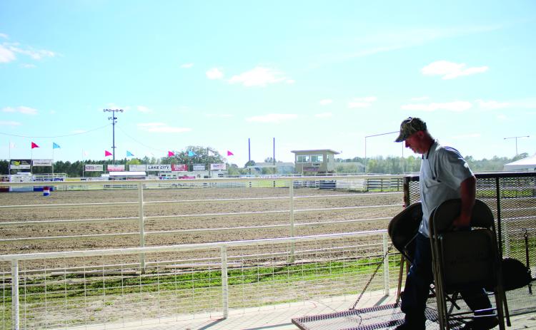 Ray Robinson sets up a row of chairs Wednesday afternoon while preparing the Florida Gateway Fairgrounds Rodeo Arena for the Florida Gateway Pro Rodeo, which takes place this weekend. (TONY BRITT/Lake City Reporter)