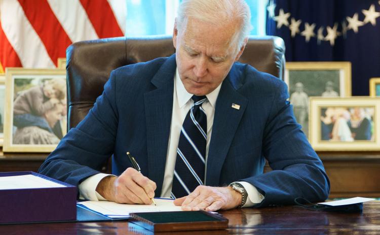 U.S. President Joe Biden signs the American Rescue Plan on Thursday in the Oval Office of the White House in Washington, D.C. (MANDEL NGAN/AFP/Getty Images/TNS)