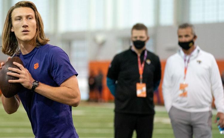 Clemson Tigers quarterback Trevor Lawrence works out as Jacksonville Jaguars head coach Urban Meyer (right) looks on during Clemson's Pro Day on Feb 12 in Clemson, S.C. (DAVID PLATT/Handout Photo via USA TODAY Sports via TNS)