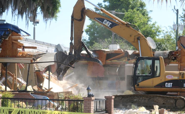 An unidentified employee from Dale’s Excavation uses an excavator to demolish the Burger King building at the intersection of West Duval Street and Southwest Main Boulevard Tuesday morning. Plans are for a new Burger King restaurant to be at the site within 30 days. (TONY BRITT/Lake City Reporter)