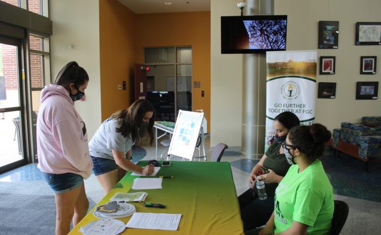 Jordan Brown (clockwise from left) looks on as Kailey Keen, signs up for FAFSA information with aid from Chelsea Allen and Meliza Acosta on Friday during Florida Gateway College’s FAFSA Marathon. (TONY BRITT/Lake City Reporter)