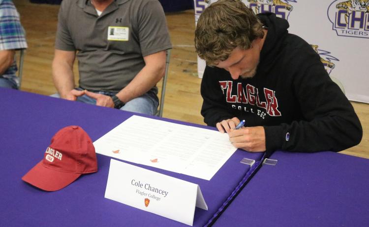 Columbia runner Cole Chancey signs his letter of intent to attend Flagler College on Wednesday. (JORDAN KROEGER/Lake City Reporter)