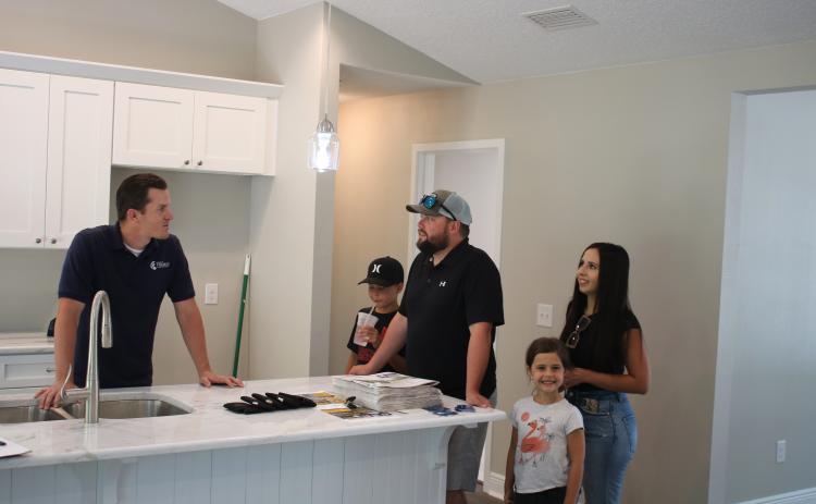 Bradley Franks (from left), of Bradley Franks Construction, talks to Stuart Morris, Jon Morris, Ashley Morris and Nora Morris on Sunday as the Morris family looks through a Bradley Franks home featured in the 2021 Parade of Homes. (TONY BRITT/Lake City Reporter)