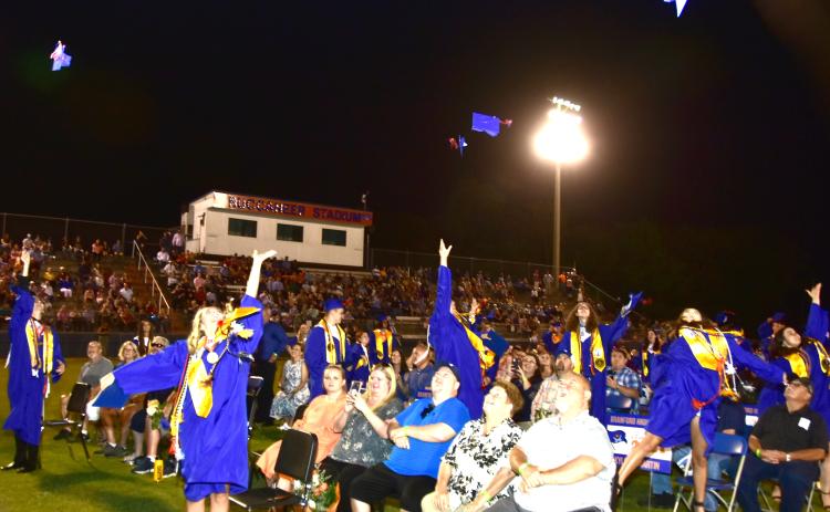 Branford High School graduates, sitting with friends and family, toss their caps into the air after their graduation ceremony at Buccaneer Stadium on Friday evening. (ROB WOLFE/Special to the Reporter)