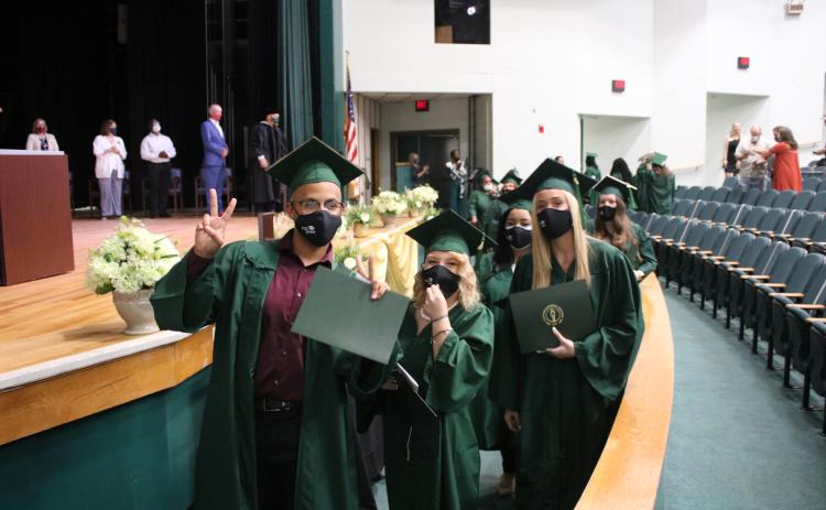 Andrey Brinson (from left), Brianna Thornton and Gabrielle Ann Gilliam pose for pictures as they exit their graduation ceremony with diplomas Tuesday afternoon at Florida Gateway College. (TONY BRITT/Lake City Reporter)