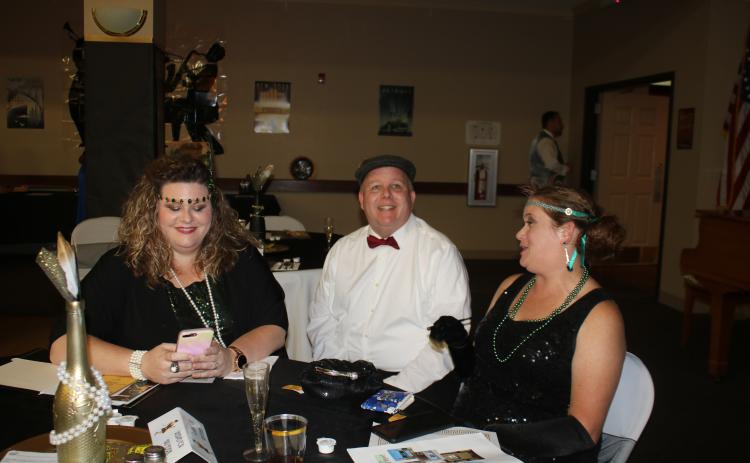 Renee Williams (from left), Columbia County Senior Services Executive Director David Huckabee and Courtney Barga share a conversation during the “Roaring 20s”, a fundraising kickoff event for Columbia County Senior Services Friday evening at the Lifestyle Enrichment Center in Lake City. (TONY BRITT/Lake City Reporter)