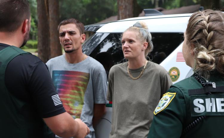 Deputies with the Columbia County Sheriff’s Office talk with Kirk Lanham and Lauryn Jones on Tuesday morning after the two were seen on surveillance cameras burglarizing a pool house on NW Streamside Court. (COURTESY COLUMBIA COUNTY SHERIFF’S OFFICE)