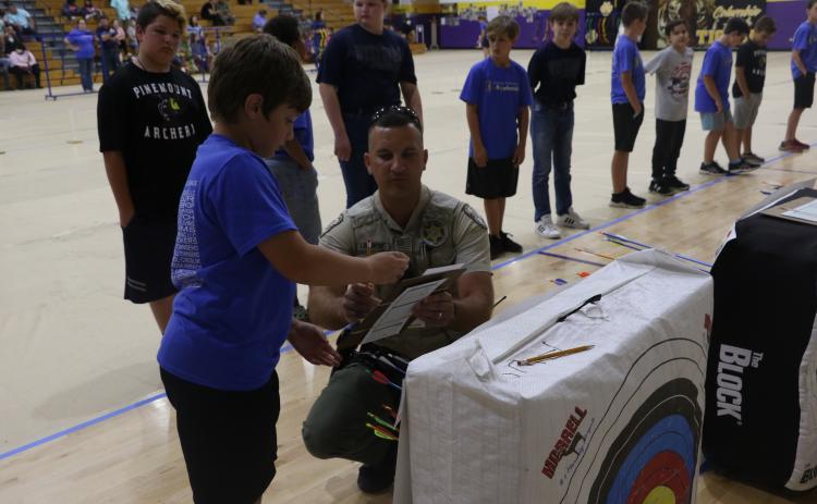 FWC Officer Luke Davenport helps an archer tally their score Friday afternoon at Columbia High School. (MORGAN MCMULLEN/Lake City Reporter)