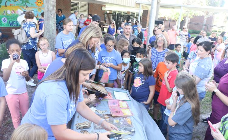 Contents from Westside Elementary's 20-year-old time capsule are laid out on a table Thursday afternoon. (MORGAN MCMULLEN/Lake City Reporter)