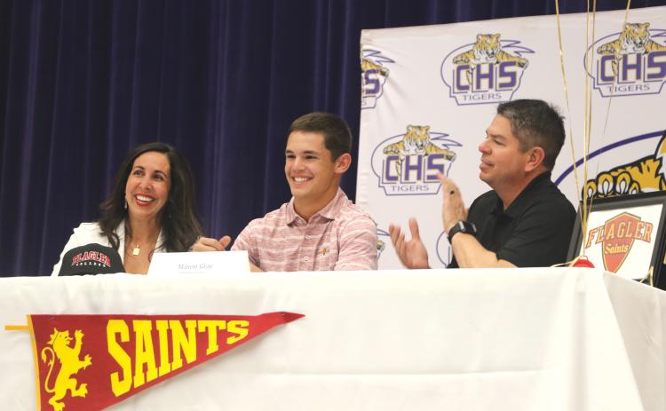 Columbia shortstop Mason Gray (middle) smiles after signing his letter of intent with Flagler alongside his mother, Heather, and father, Kevin, on Tuesday. (MORGAN MCMULLEN/Lake City Reporter)