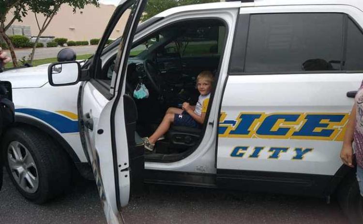 Five-year-old Wyatt Griffis sits in the patrol vehicle of Lake City police officer Michael Craig following an interaction between the two near a Dollar Tree store. (COURTESY)
