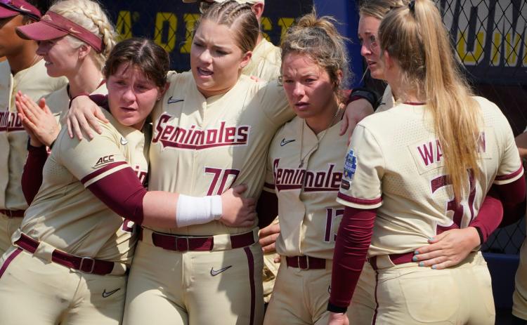 Florida State players Kaia LoPreste (from left), Cassidy Davis, Anna Shelnutt, Emma Wilson and Danielle Watson watch as Oklahoma players accept awards after they defeated Florida State in the final game of the Women's College World Series championship series Thursday in Oklahoma City. (SUE OGROCKI/Associated Press)