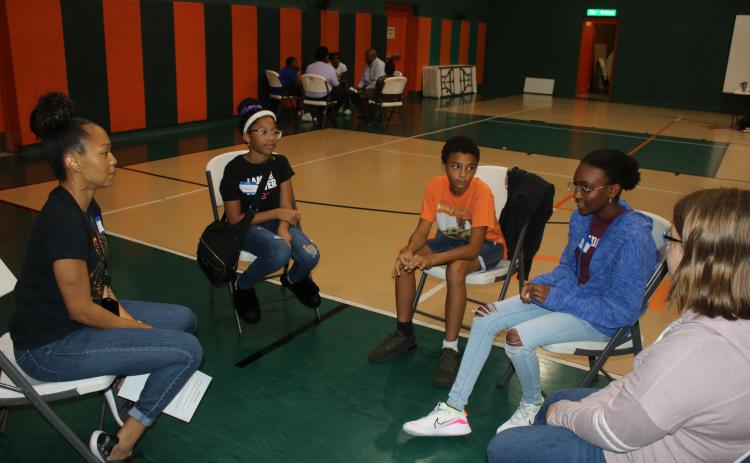 Tanya Parker (far left) leads students in a discussion about the Tulsa Massacre during a Northstar Family Resource Center Juneteenth program Thursday. (TONY BRITT/Lake City Reporter)
