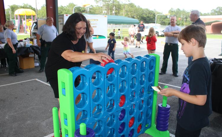 Jean Hamm (left) plays Connect Four with her grandson, Titan Turner, 9, during the Columbia County Sheriff’s Office Summer Nights event Friday night at Five Points Elementary School. (TONY BRITT/Lake City Reporter)