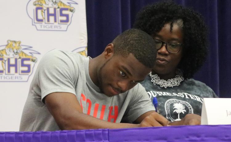 Columbia track & field athlete James Williamson signs his letter of intent with Southeastern University on Wednesday. (JORDAN KROEGER/Lake City Reporter)