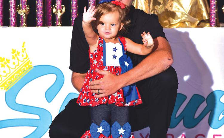 Julia Miller shows off her red, white and blue outfit alongside her father, Jevon, at the Florida Sunburst Beauty Pageant competition. (COURTESY)