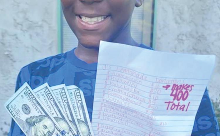 Ja’Marion West shows off his collected donations along with a list of those who helped him raise the $400. (COURTESY)