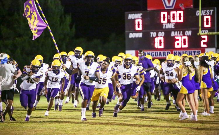 Columbia defensive end Adeon Farmer raises the team flag as he leads the Tigers onto the field prior to their Preseason Classic against Vanguard on Aug. 20. (BRENT KUYKENDALL/Lake City Reporter)