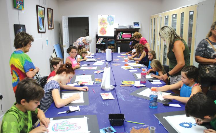 A group of students work on artwork Friday at the Gateway Art Gallery. Local artists served as instructors for the classes. (TONY BRITT/Lake City Reporter)