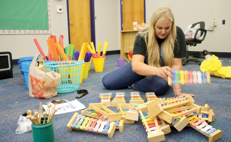 Dianna Swisher, the Columbia County School District’s volunteer and marketing coordinator, sorts through xylophones for Ginger Norris’s renovated music room at Fort White Elementary School. (TONY BRITT/Lake City Reporter)