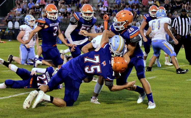 Branford defensive lineman Cole Certain (75) and linebacker Seth Humphries (28) make a tackle against Chiefland in the Preseason Classic on Aug. 20. (ROB WOLFE/Special to the Reporter)