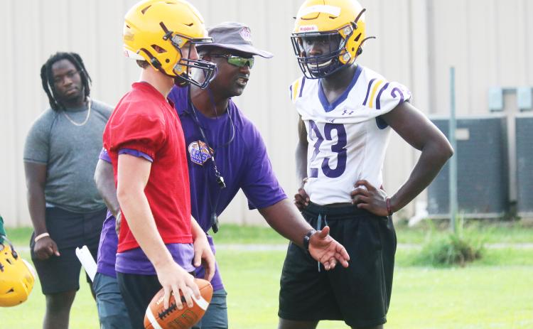 Columbia head coach Demetric Jackson (middle) instructs quarterback Kade Jackson (left) and running back Malik Moore (right) during practice on Monday. (JORDAN KROEGER/Lake City Reporter)