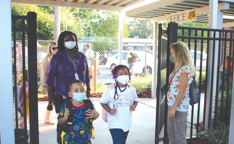 Jeanette Young (far right), an Eastside Elementary School employee, welcomes kindergartners and their parents to campus for the first day of school. (TONY BRITT/Lake City Reporter)