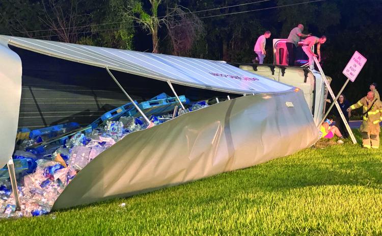 A tractor trailer hauling botted water overturned at the B&B Food Store on State Road 47 in Columbia City on Monday night. (JAMIE WACHTER/Lake City Reporter)