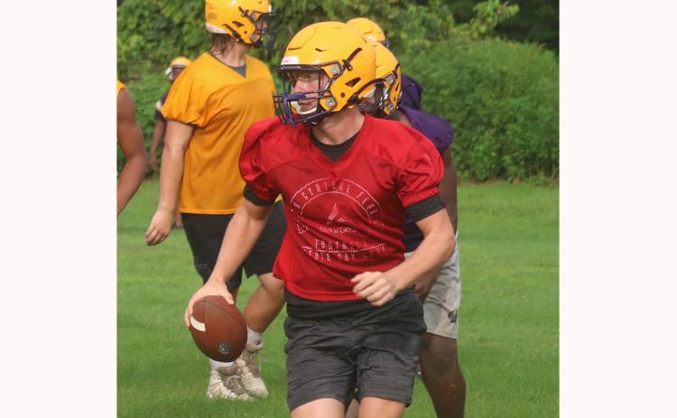 Columbia quarterbacks Kade Jackson looks down the field to throw as he escapes pressure from the defense during practice on Tuesday. (JORDAN KROEGER/Lake City Reporter)