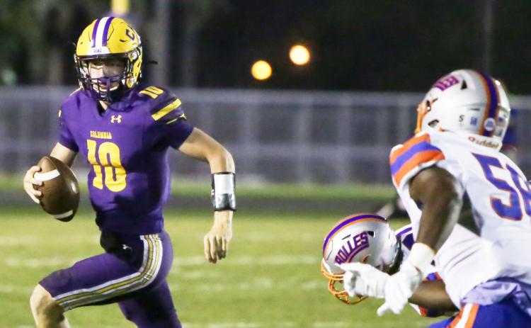 Columbia quarterback Kade Jackson scrambles away from pressure against Bolles on Friday night. (BRENT KUYKENDALL/Lake City Reporter)