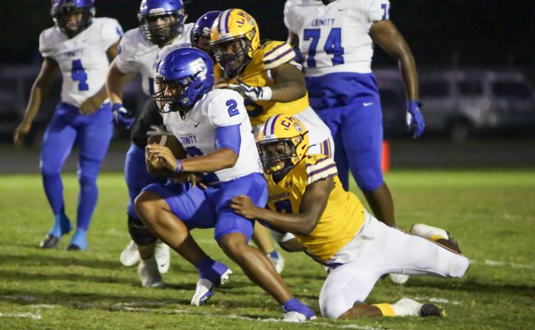 Columbia defensive end Adeon Farmer (7) attempts to tackle Trinity Christian quarterback Colin Hurley as defensive tackle Garris Reed (58) gives chase last Friday. (BRENT KUYKENDALL/Lake City Reporter)