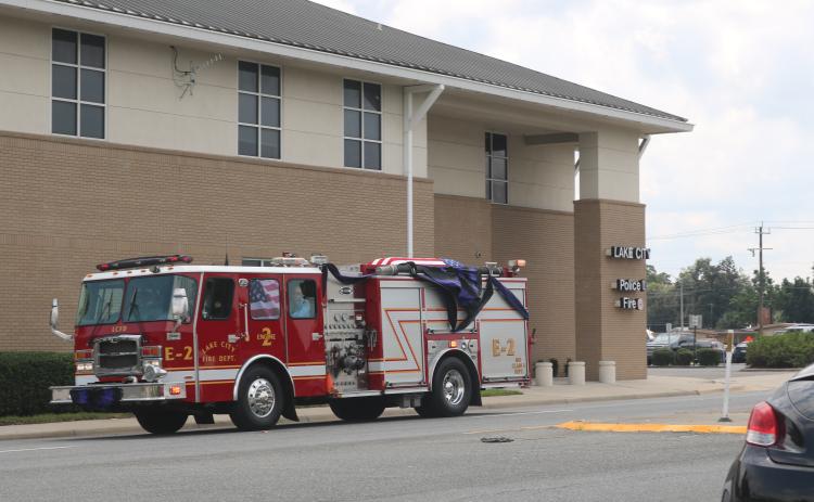 A Lake City fire truck carrying Randy Burnham, the city’s fallen fire chief, passes by the Lake City Fire Department Station 1 on Friday afternoon on its way to the Corinth Methodist Church cemetery. (JAMIE WACHTER/Lake City Reporter)