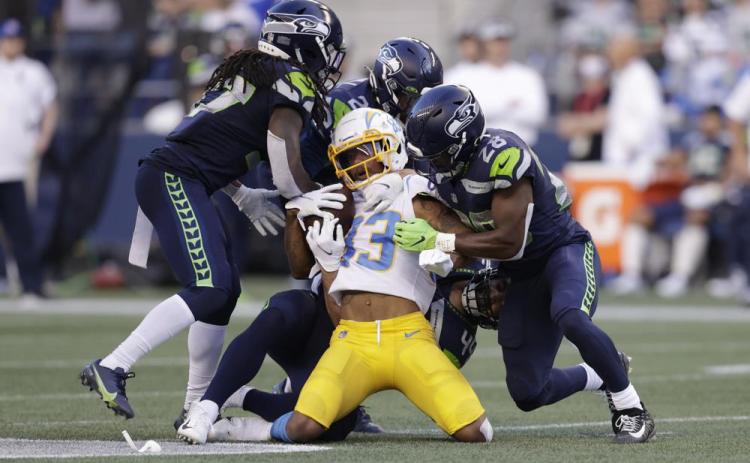 Los Angeles Chargers wide receiver Tyron Johnson, center, is brought down by Seattle Seahawks' Marquise Blair, Damarious Randall and Ugo Amadi, from left, during a preseason game on Aug. 28 in Seattle. (JOHN FROSCHAUER/Associated Press)